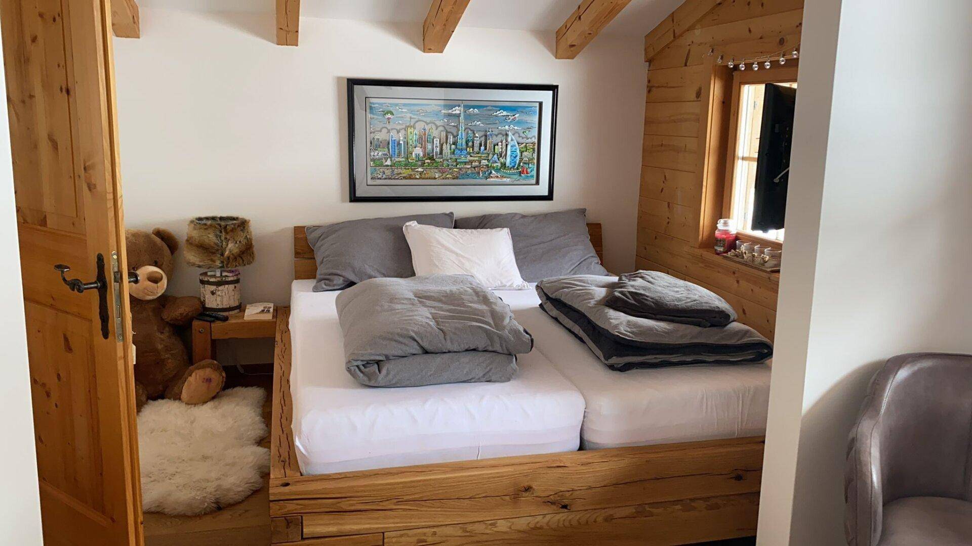 Rustikales Schlafzimmer mit Holzbett, Holzwänden und gemütlicher Atmosphäre.