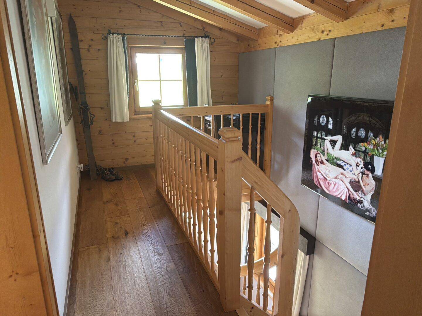 Heller Flur mit Holztreppe und Holzboden, der die oberen Etagen verbindet.