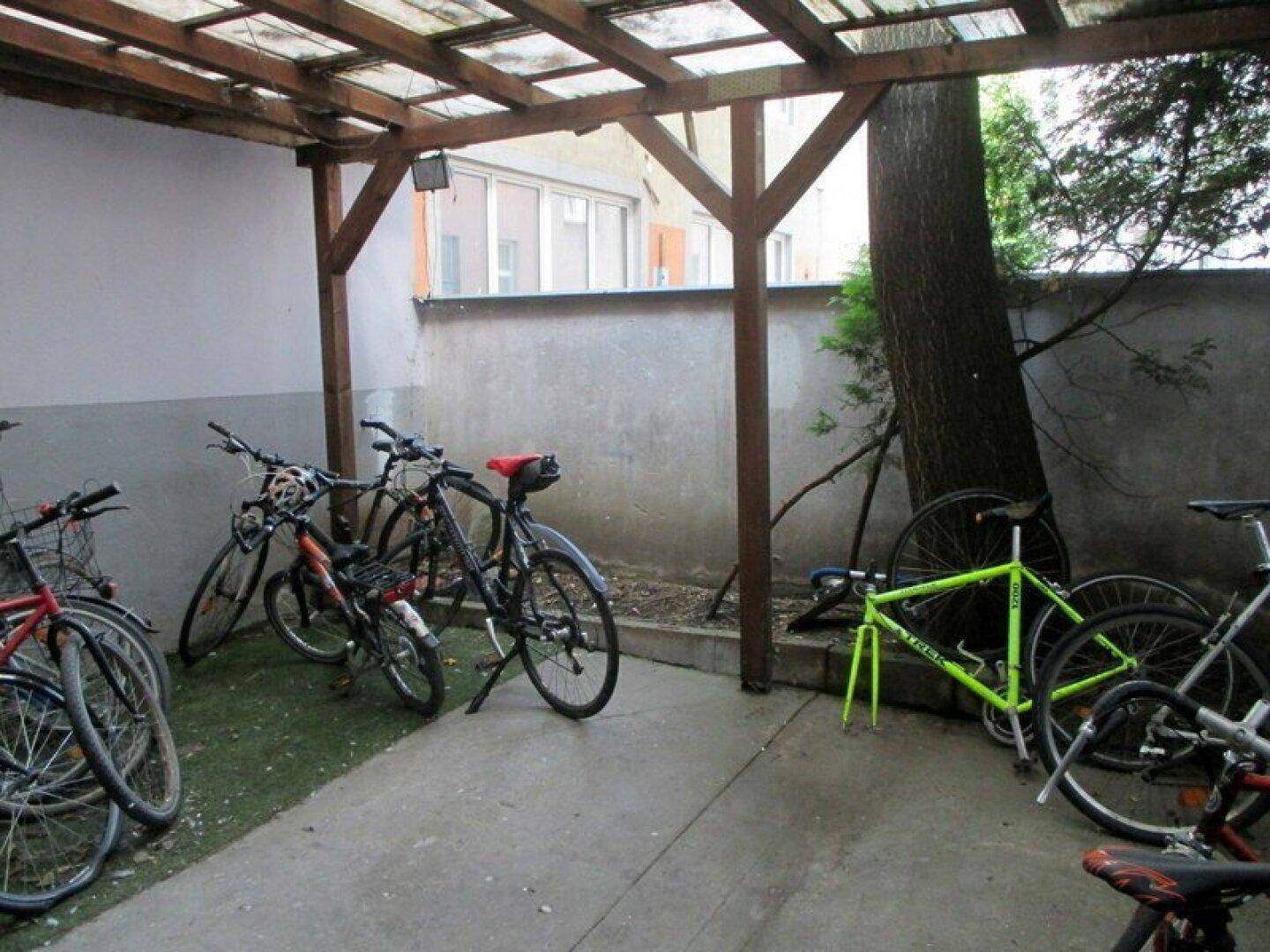 Überdachter Fahrradabstellplatz im Freien mit Holzkonstruktion und mehreren Fahrrädern.