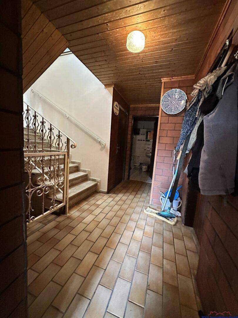 Eingangsbereich mit rustikalen Holzdecken, Ziegelwänden und gefliestem Boden.