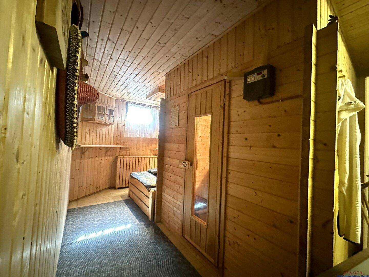Wellnessbereich im Untergeschoss mit holzvertäfelter Sauna und Ruhemöglichkeit.