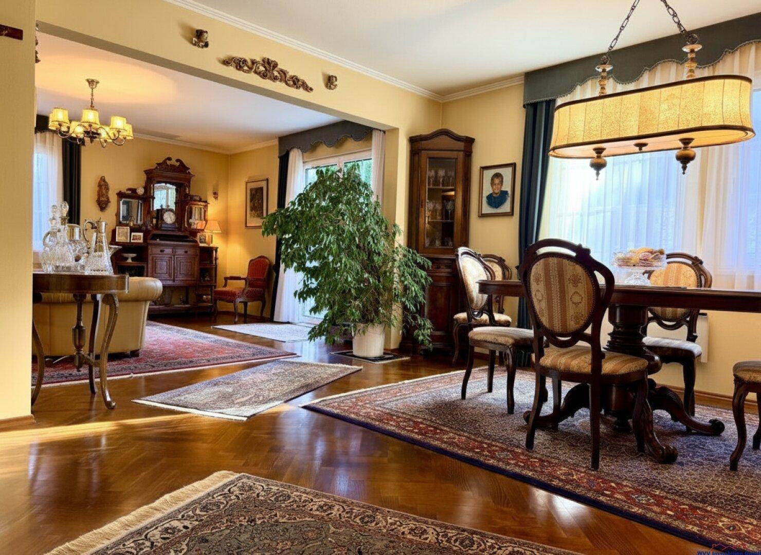 Eleganter Wohn- und Essbereich im klassischen Stil mit dunklen Holzmöbeln und Parkettboden.