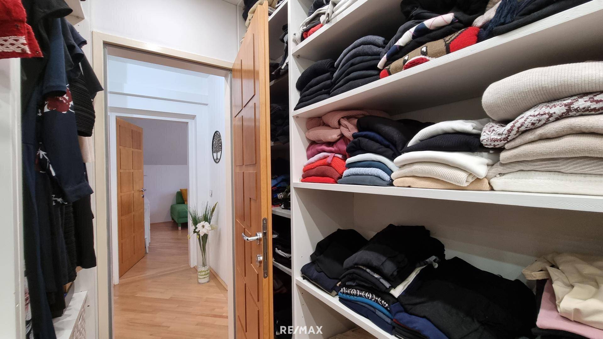 Praktischer begehbarer Kleiderschrank mit viel Stauraum und Regalen für Kleidung und Accessoires.