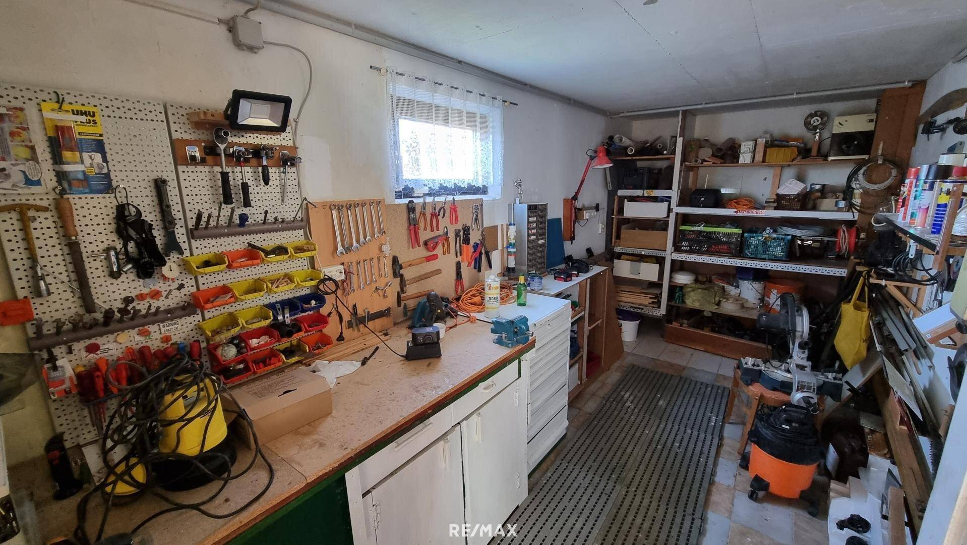Gut ausgestattete Werkstatt im Keller mit Werkbank und vielen Werkzeugen.