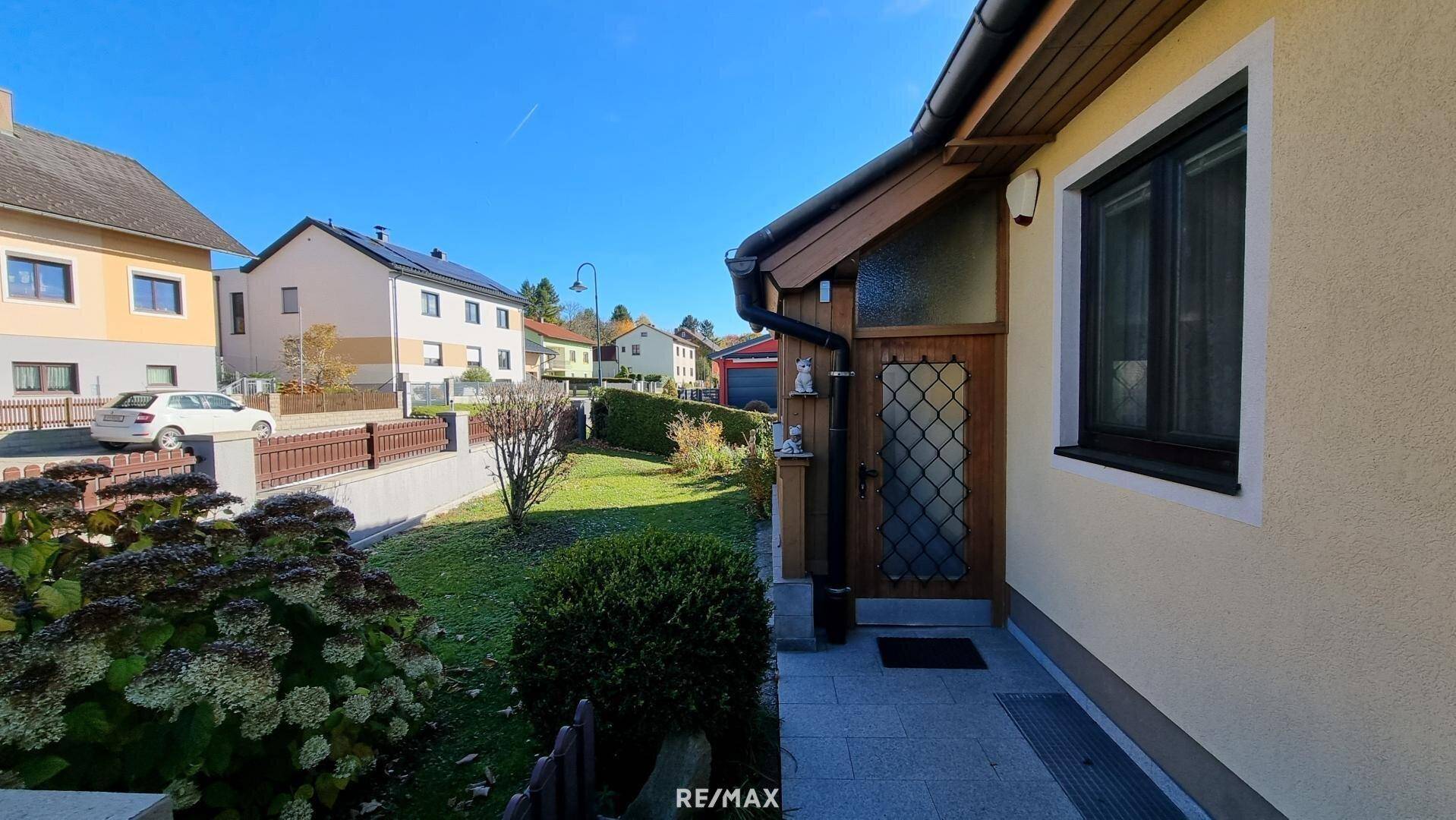 Eingangsbereich des Hauses mit gepflegtem Vorgarten und Zugang zur Straße.