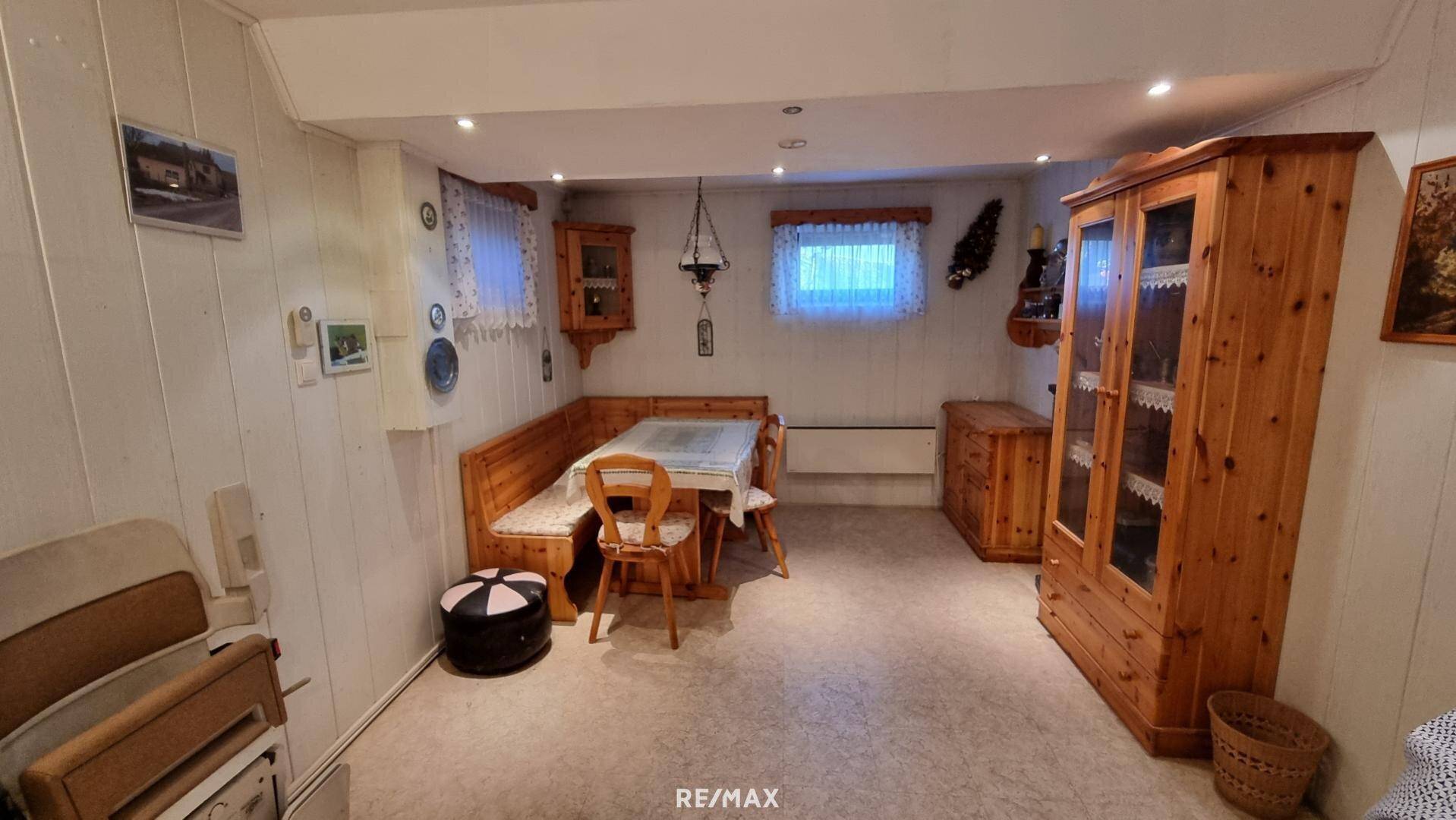 Gemütlicher Hobbyraum im Keller mit Essbereich und Holzmöbeln.