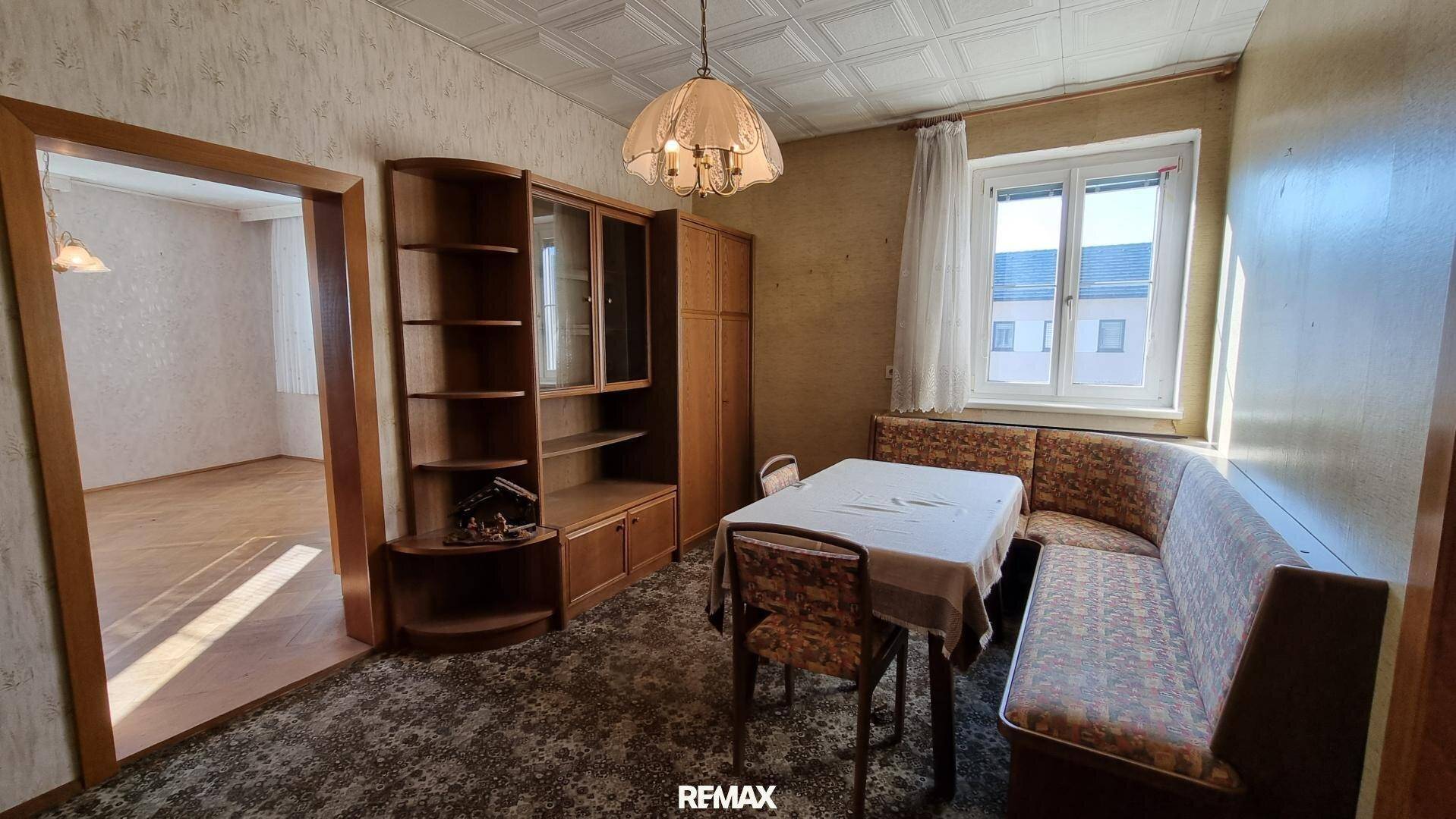 Esszimmer mit Eckbank, Holztisch und einem Schrank, in traditionellem Stil eingerichtet.