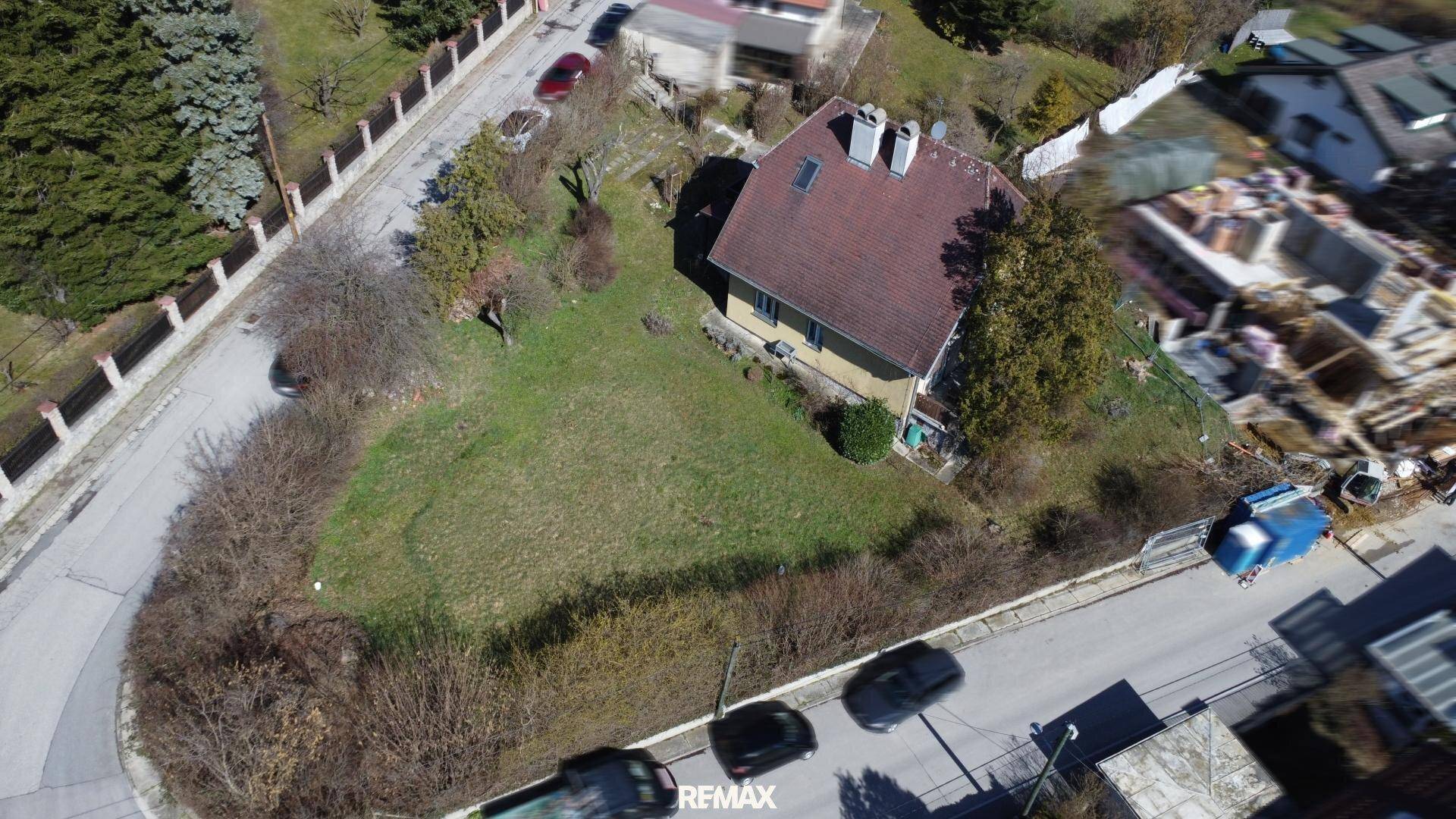 Luftaufnahme eines Hauses mit großem Garten und umliegenden Straßen in ländlicher Gegend.