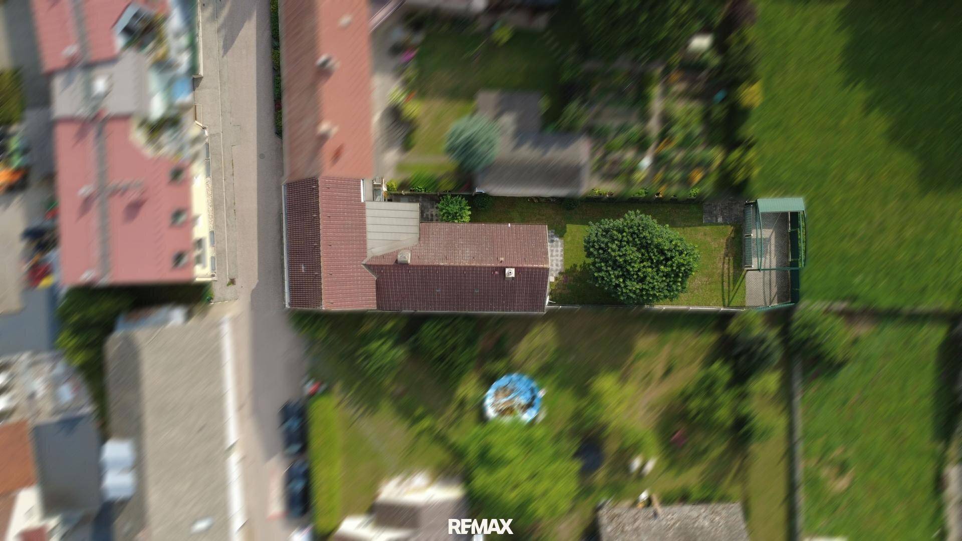 Vogelperspektive des Grundstücks mit Haus, Garten und Carport in ländlicher Umgebung.