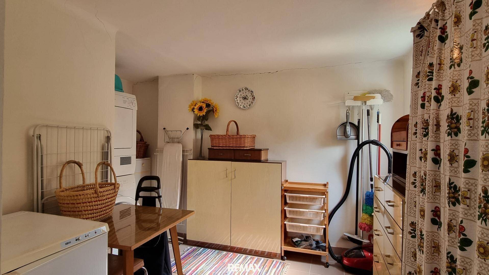 Hauswirtschaftsraum mit Waschmaschine, Trockner und Stauraum für Haushaltsgeräte.