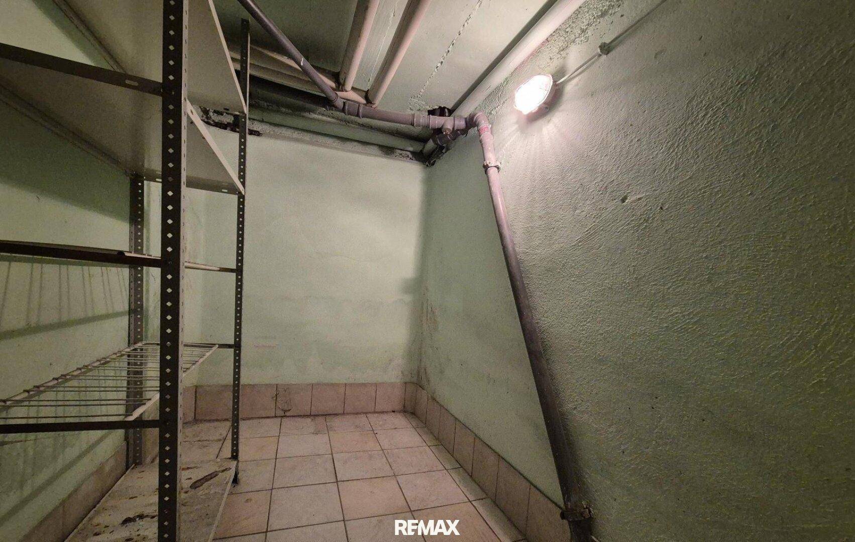 Lagerraum im Keller mit Regalen und gefliestem Boden, ideal für Vorräte und Aufbewahrung.