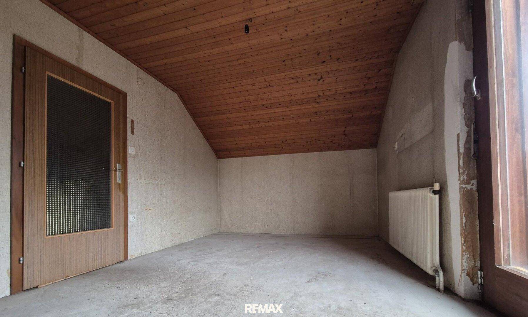 Dachbodenraum mit Holzdecke und rohen Wänden, ideal für zukünftige Nutzung nach Renovierung.