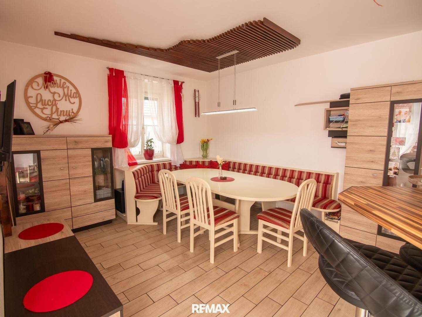 Gemütlicher Essbereich mit Holzboden, gepolsterter Eckbank und modernem Deckendesign.