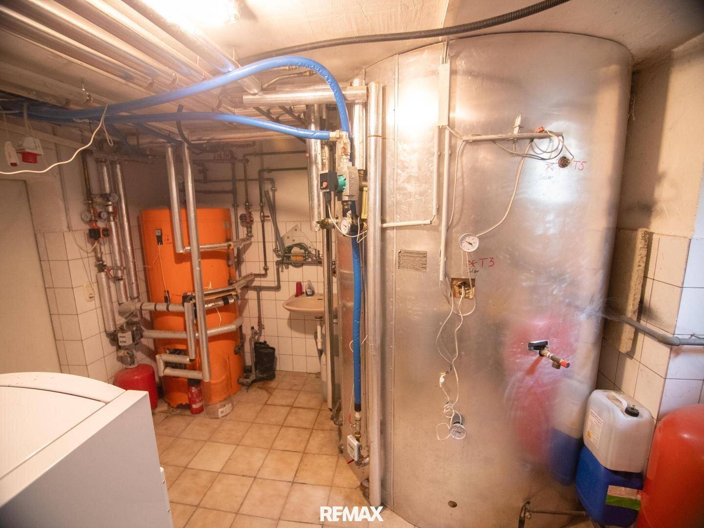 Technischer Raum mit Heizungsanlage und großen Speichertanks, sauber und gut organisiert.