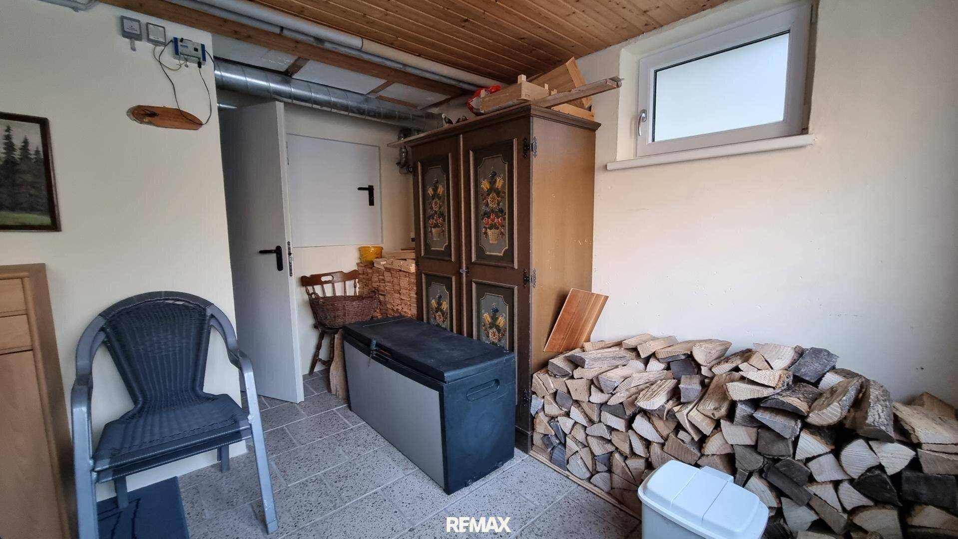 Abstellraum mit Holzstapel, Schrank und Fenster, ideal für Lagerung.