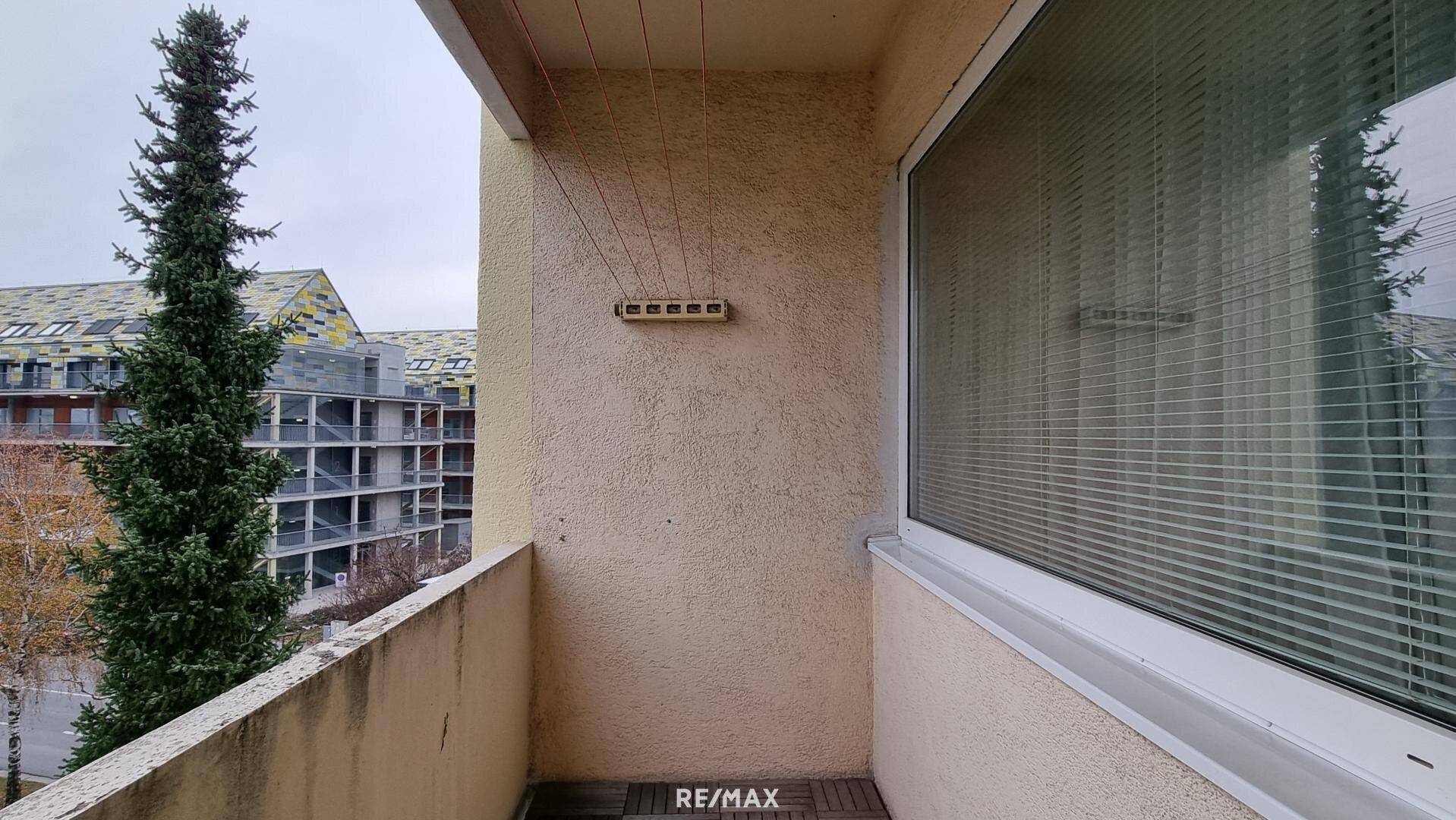 Kleiner Balkon mit Wäscheleine und Blick auf die umliegenden Gebäude.