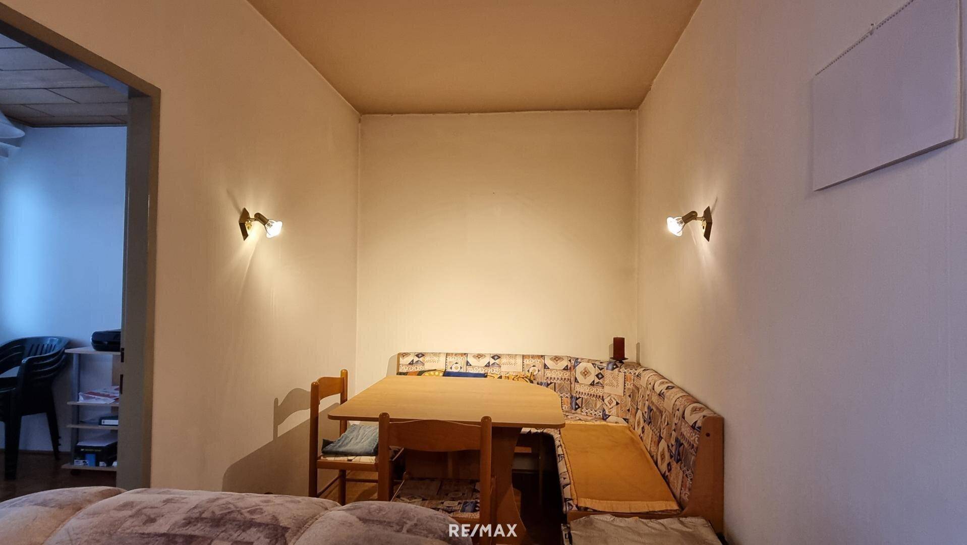 Heller Essbereich mit Holztisch, Eckbank und Wandleuchten für eine angenehme Atmosphäre.