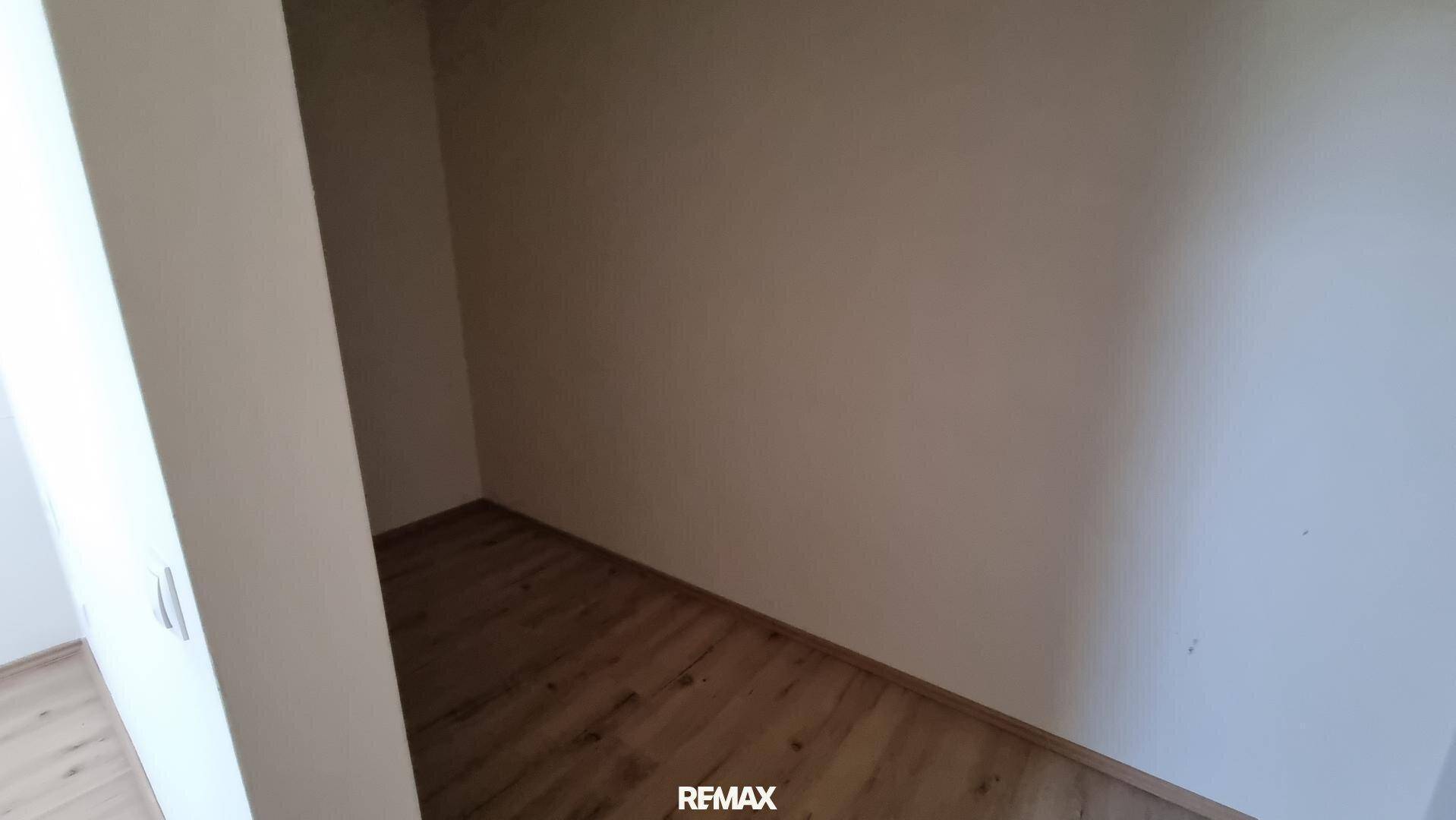 Kleiner leerer Raum mit hellem Laminatboden und weißen Wänden, der als Abstellraum genutzt werden könnte.
