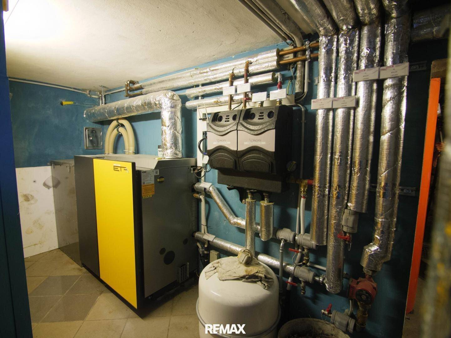 Heizungsraum mit moderner Heizungsanlage und isolierten Rohren.