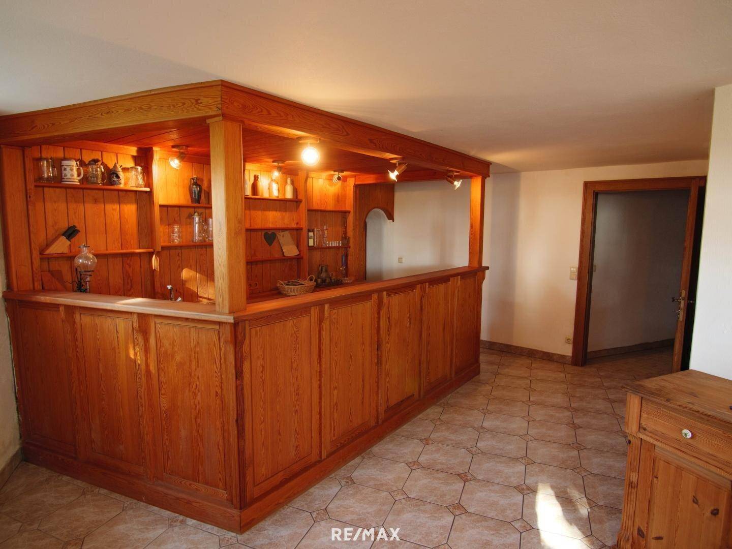 Gemütliche Holzbar im Keller mit Regalen und traditioneller Einrichtung.