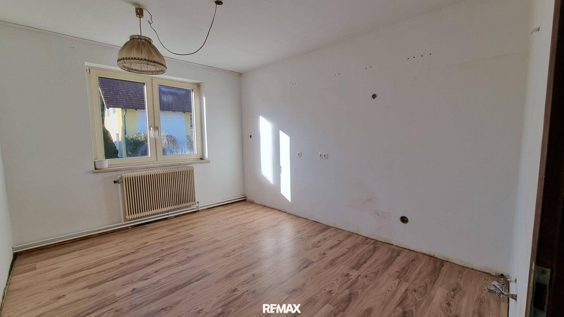 Geräumiges Schlafzimmer mit Laminatboden und viel Tageslicht durch das Fenster.