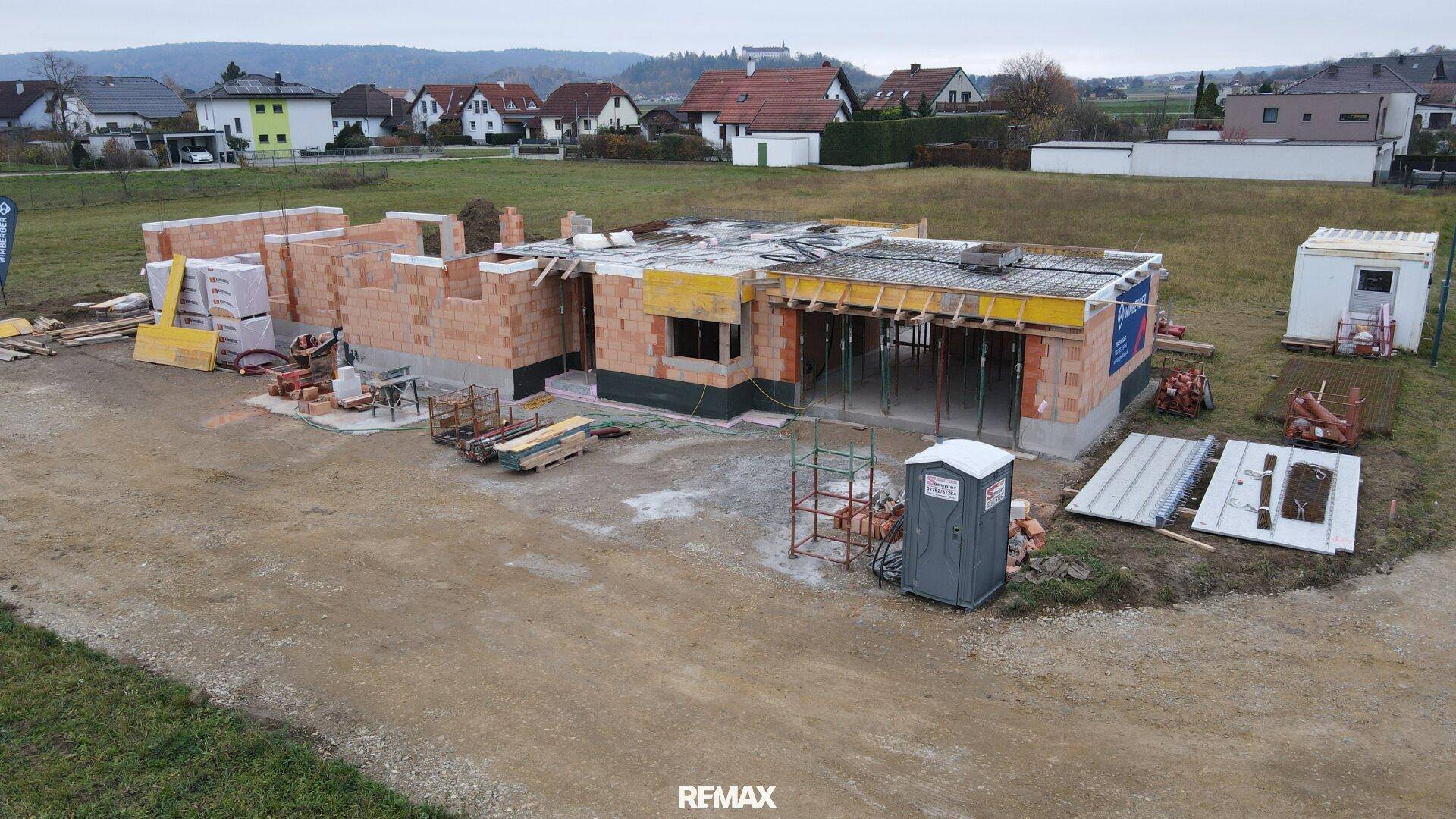 Luftaufnahme einer Baustelle mit Rohbau des ersten Obergeschosses und Schalung.