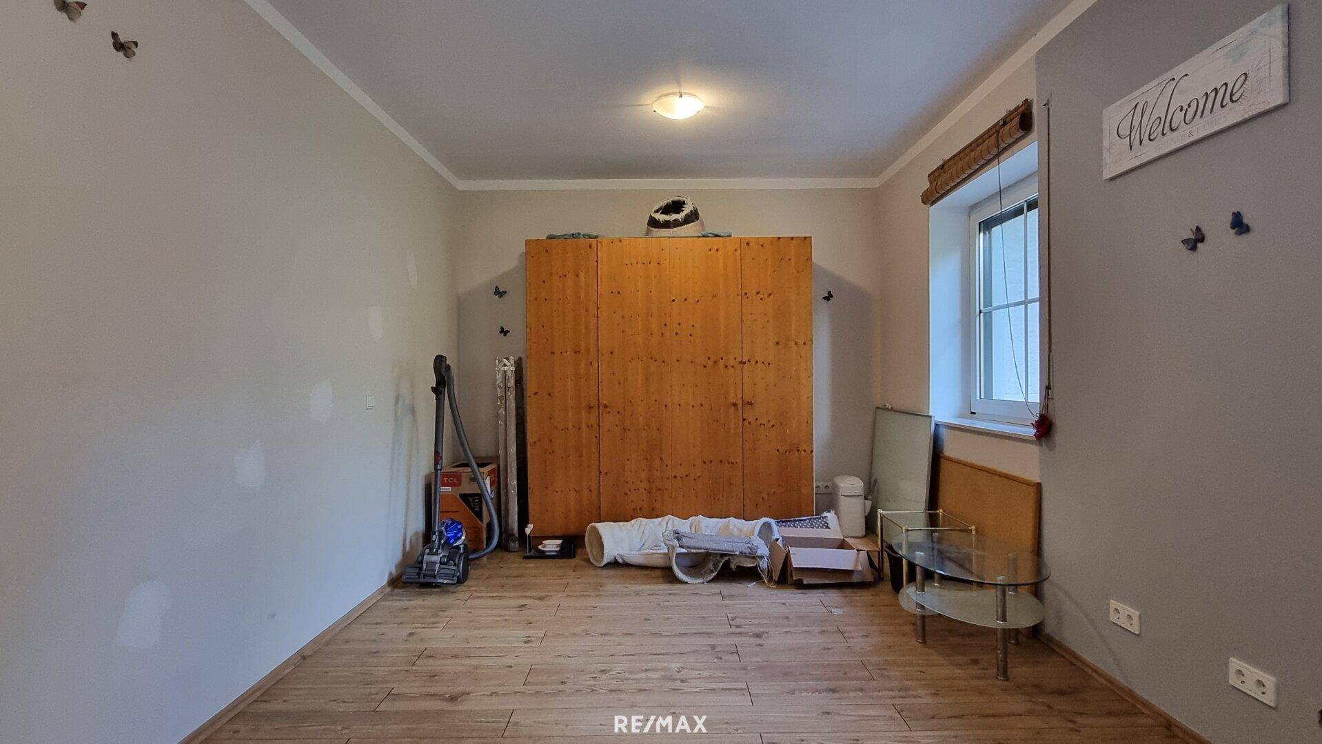 Geräumiges Zimmer mit Holzboden und großem Holzschrank, vielseitig nutzbar.