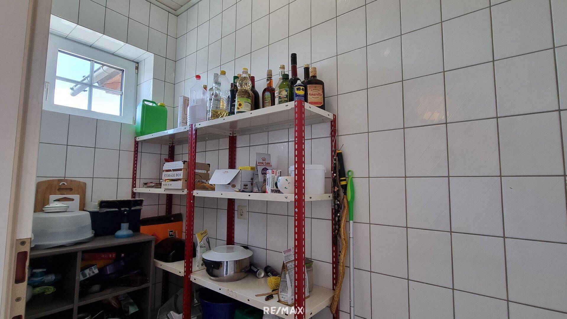 Praktischer Abstellraum mit Regalen für Vorräte und Haushaltsartikel.