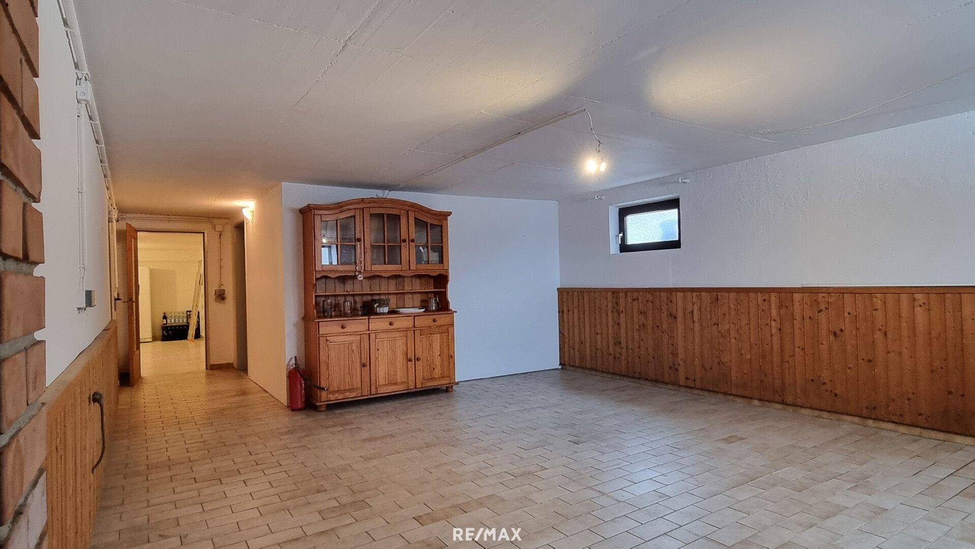 Geräumiger Kellerraum mit Fliesenboden und Holzvertäfelung, vielseitig nutzbar.