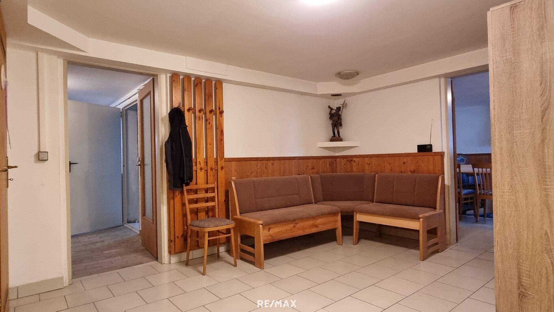 Gemütlicher Wohnbereich im Keller mit Eckbank und Holzvertäfelung.