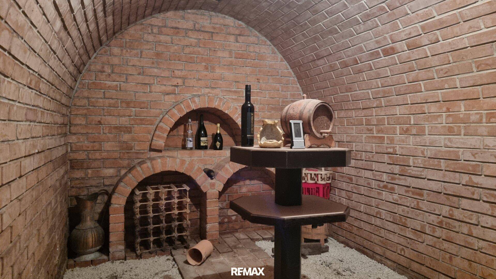 Gemütlicher Weinkeller mit Ziegelgewölbe, integrierten Weinregalen und rustikaler Einrichtung.
