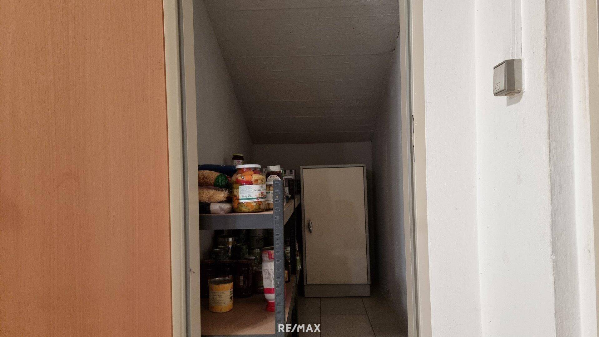 Kleiner Abstellraum mit Regalen für Vorräte und Haushaltsgegenstände.