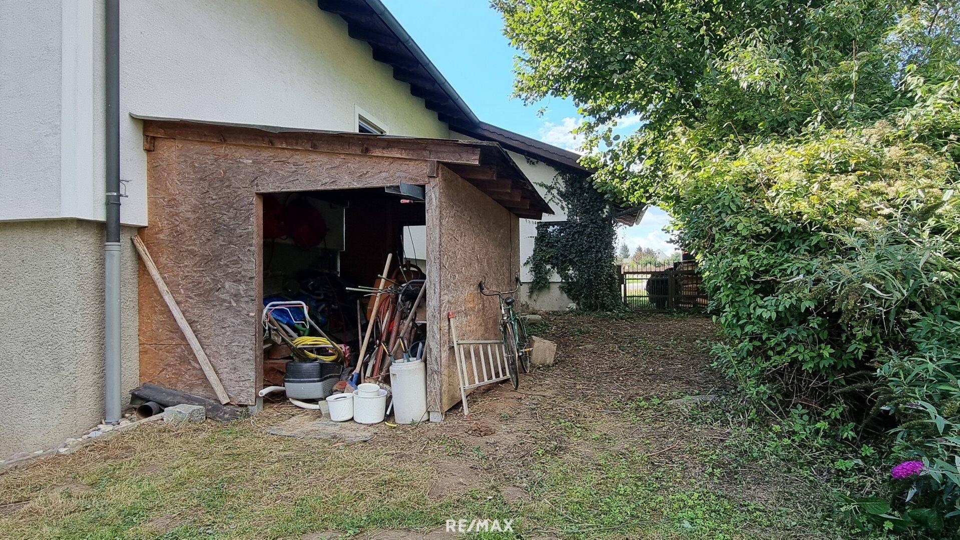 Einfacher Holzschuppen im Gartenbereich für Gartengeräte und Lagerung.