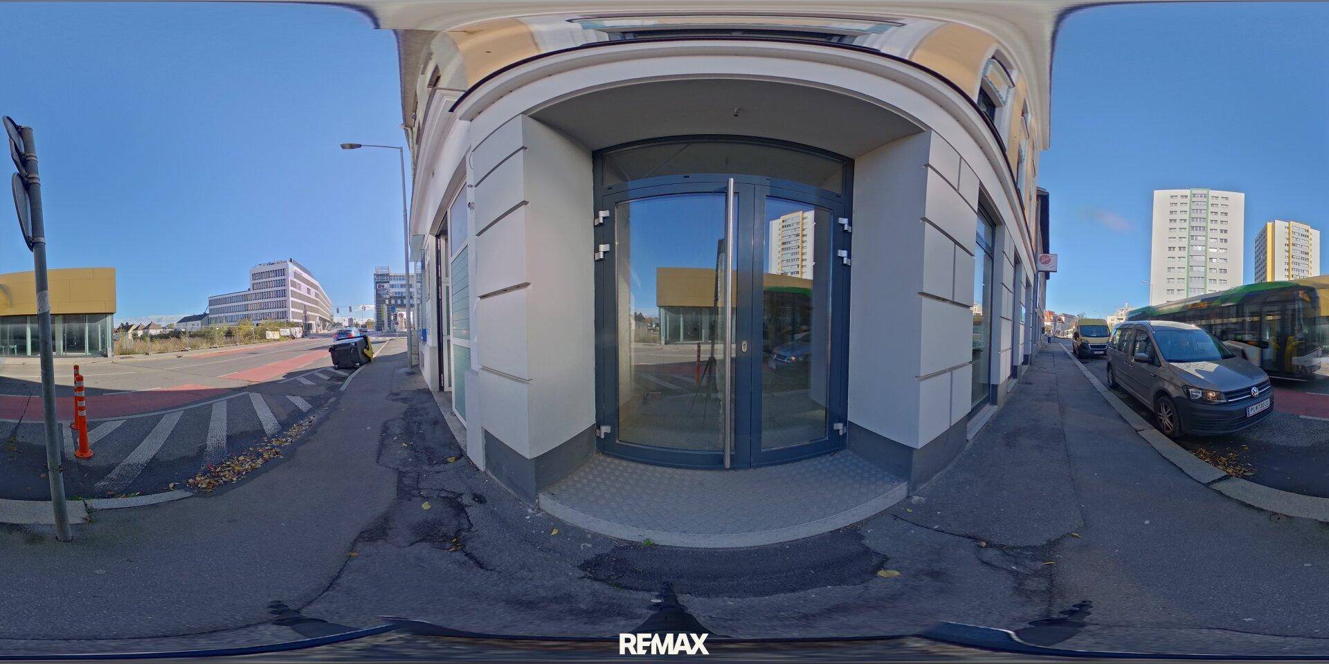 Panoramaansicht einer Straßenecke mit dem Geschäftsgebäude und umliegender Stadtlandschaft.