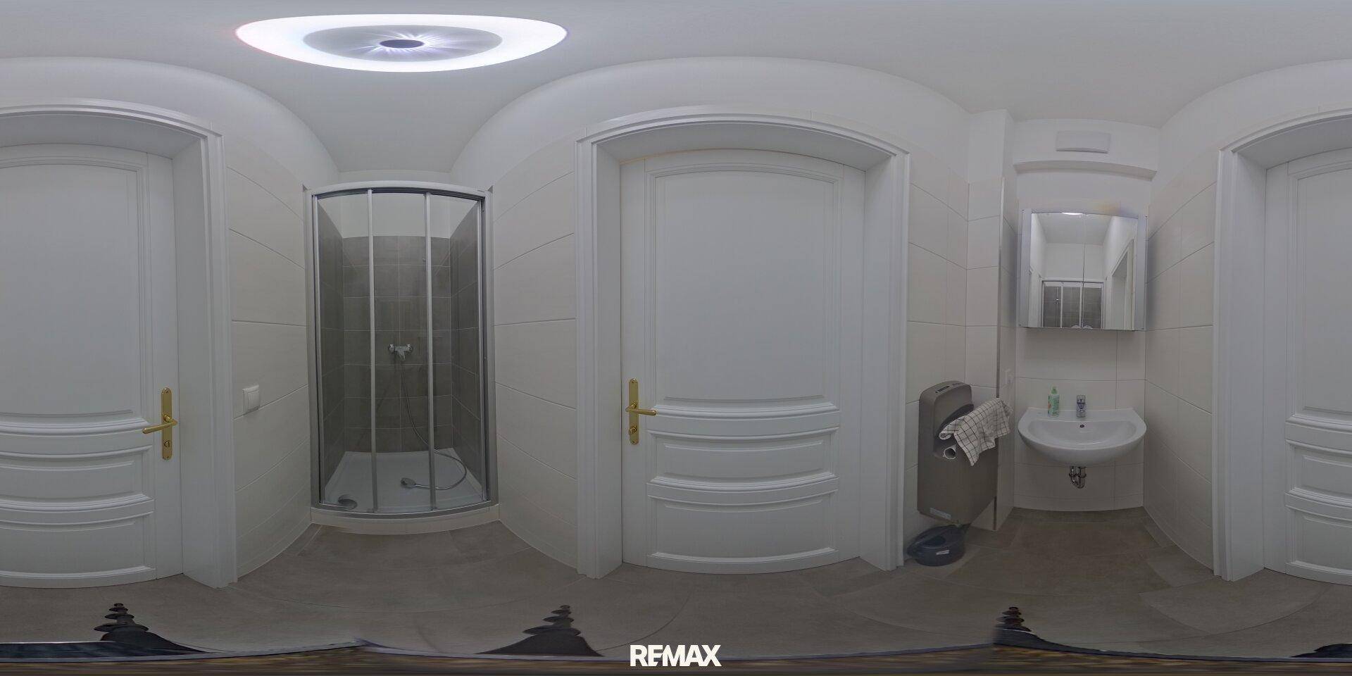 Helles Badezimmer mit Duschkabine, Waschbecken und weißen Fliesen, funktional und sauber.