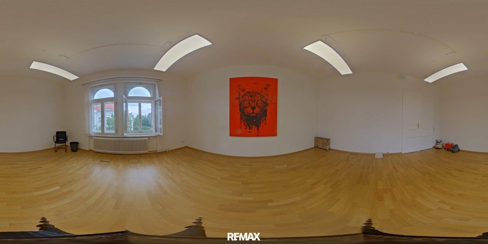Panoramaansicht eines leeren Raumes mit Holzboden, großen Fenstern und einem roten Kunstwerk.