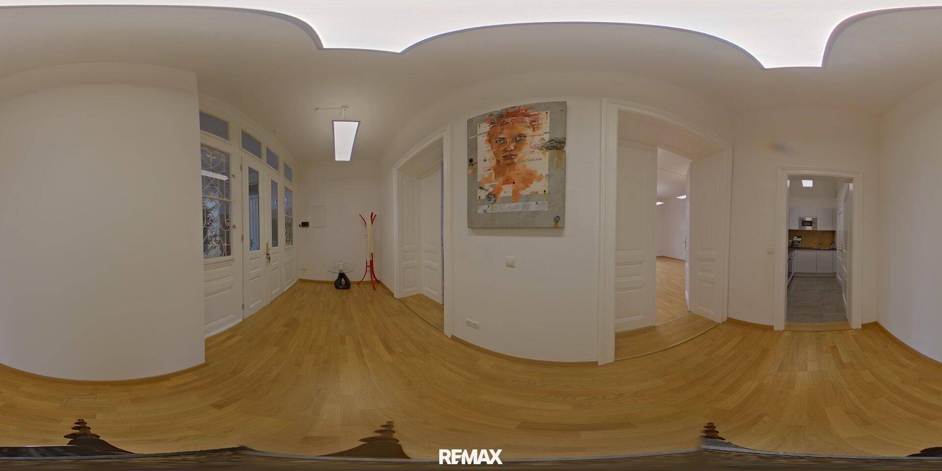Panoramaansicht eines langen Flurs mit Holzboden, weißen Türen und einem Gemälde an der Wand.