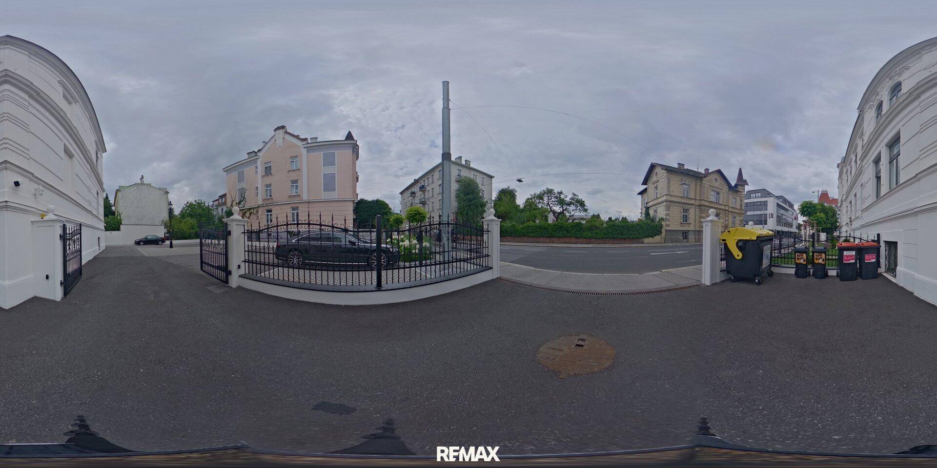 Panoramaansicht des Außenbereichs mit Parkplätzen und den umliegenden historischen Gebäuden.