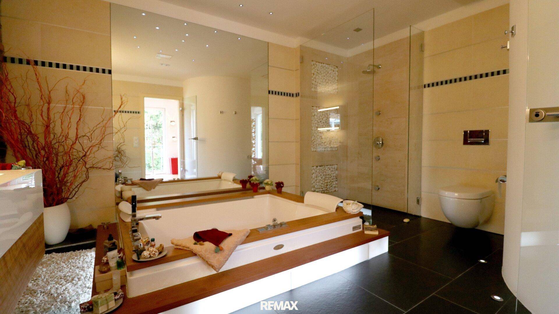 Modernes Badezimmer mit großer Badewanne, begehbarer Dusche und eleganten Fliesen.