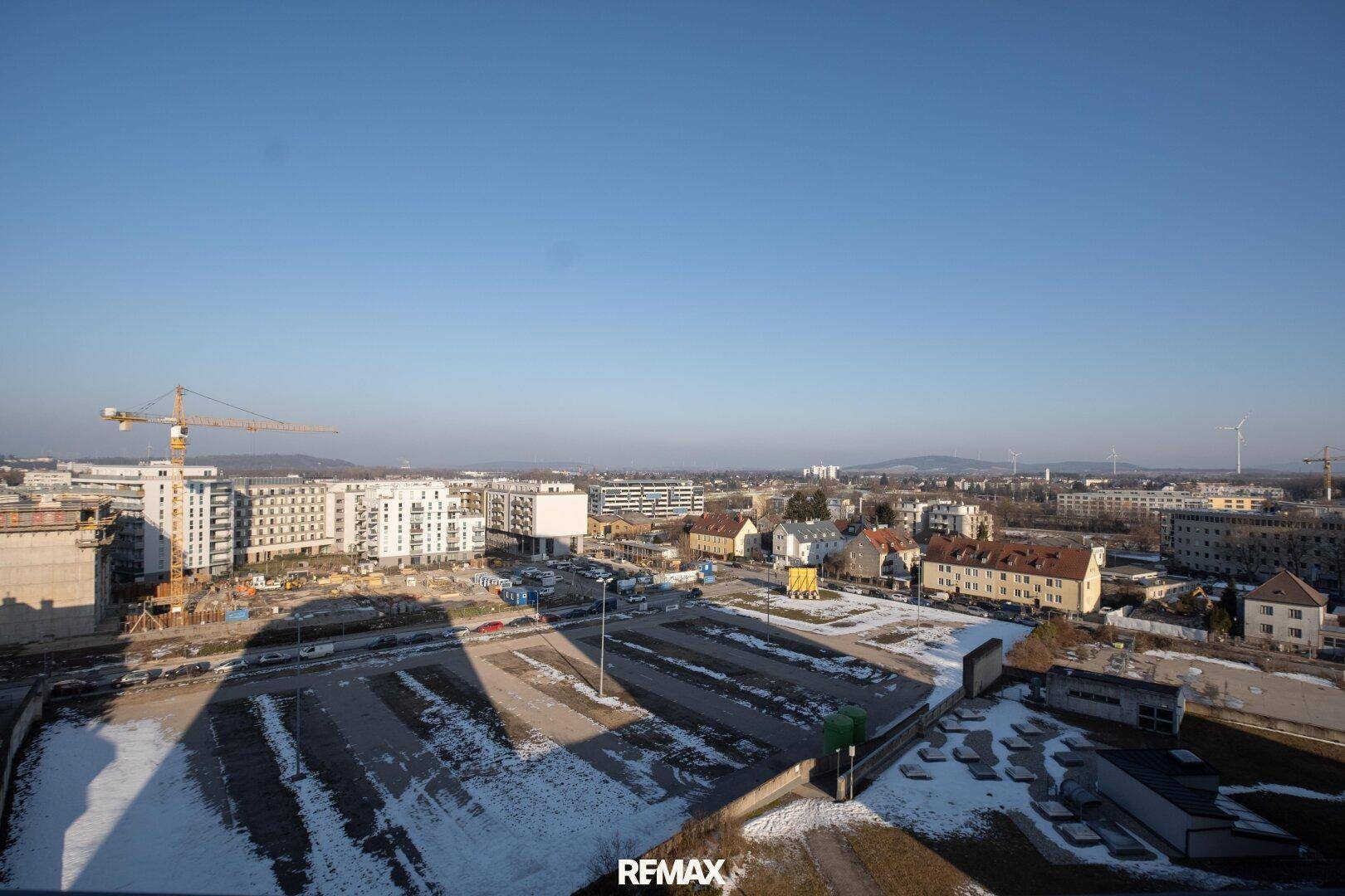 Umfassender Stadtblick mit Baustellen, neuen Gebäuden und urbaner Entwicklung in der Ferne.