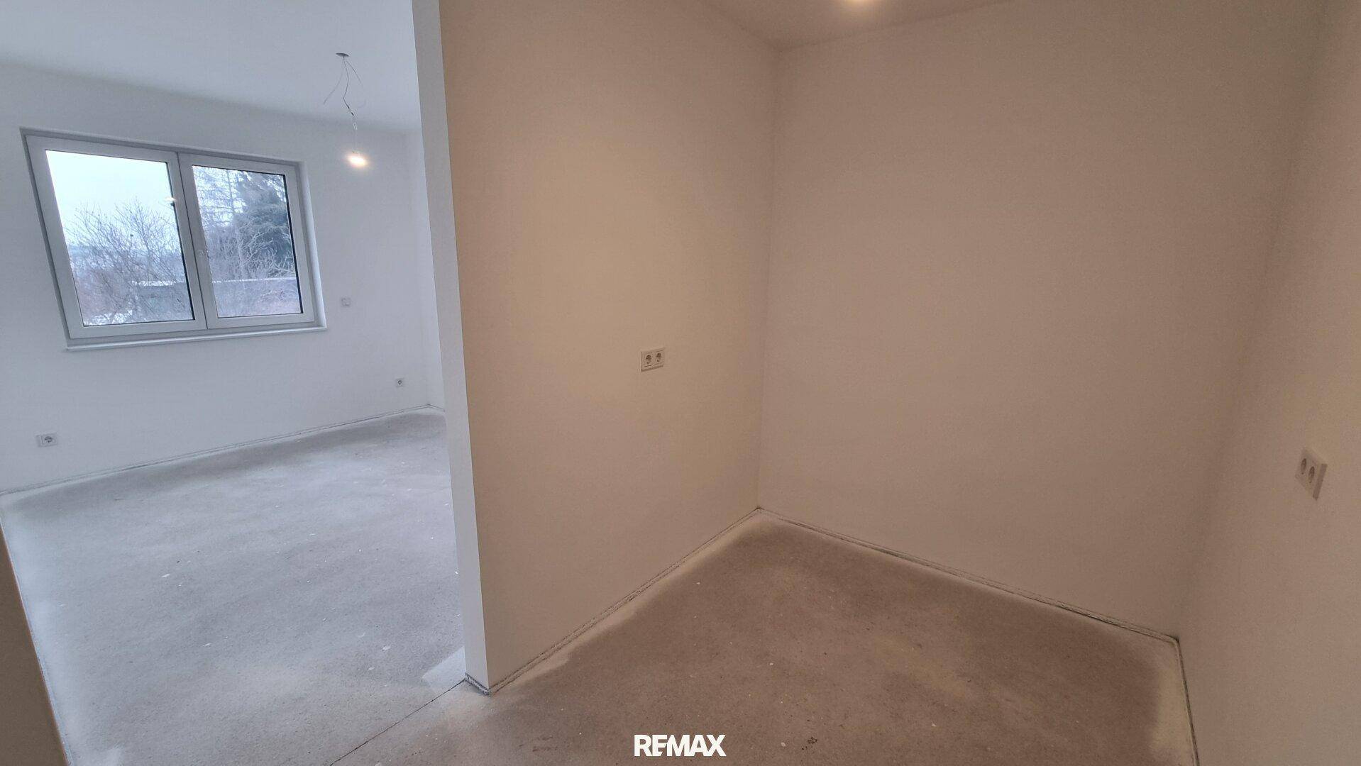 Unfertiges Schlafzimmer oder Büro mit großen Fenstern und vorbereitetem Bodenbelag.