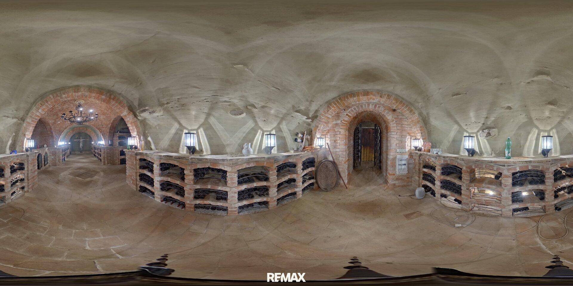Weitläufiger Panoramablick in einen Weinkeller mit Ziegelgewölben und zahlreichen Weinregalen.