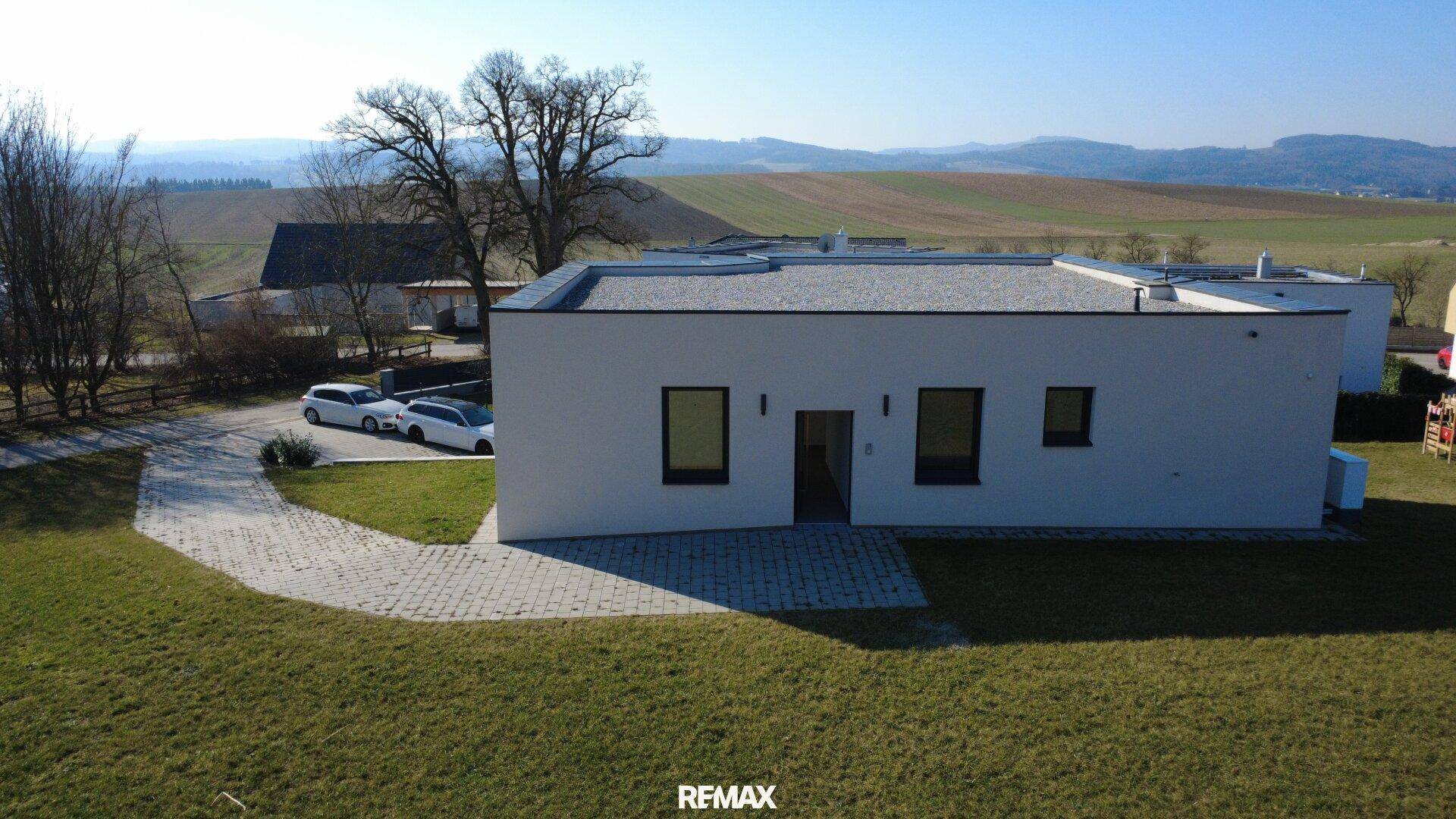 Modernes Einfamilienhaus in ländlicher Umgebung mit gepflegtem Vorgarten und Weitblick.
