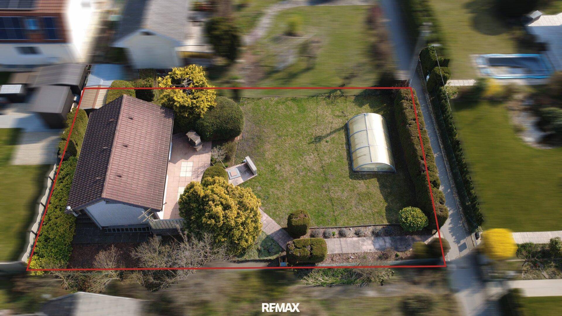 Übersicht des Grundstücks mit Einfamilienhaus und Garten, umrandet von Hecken.