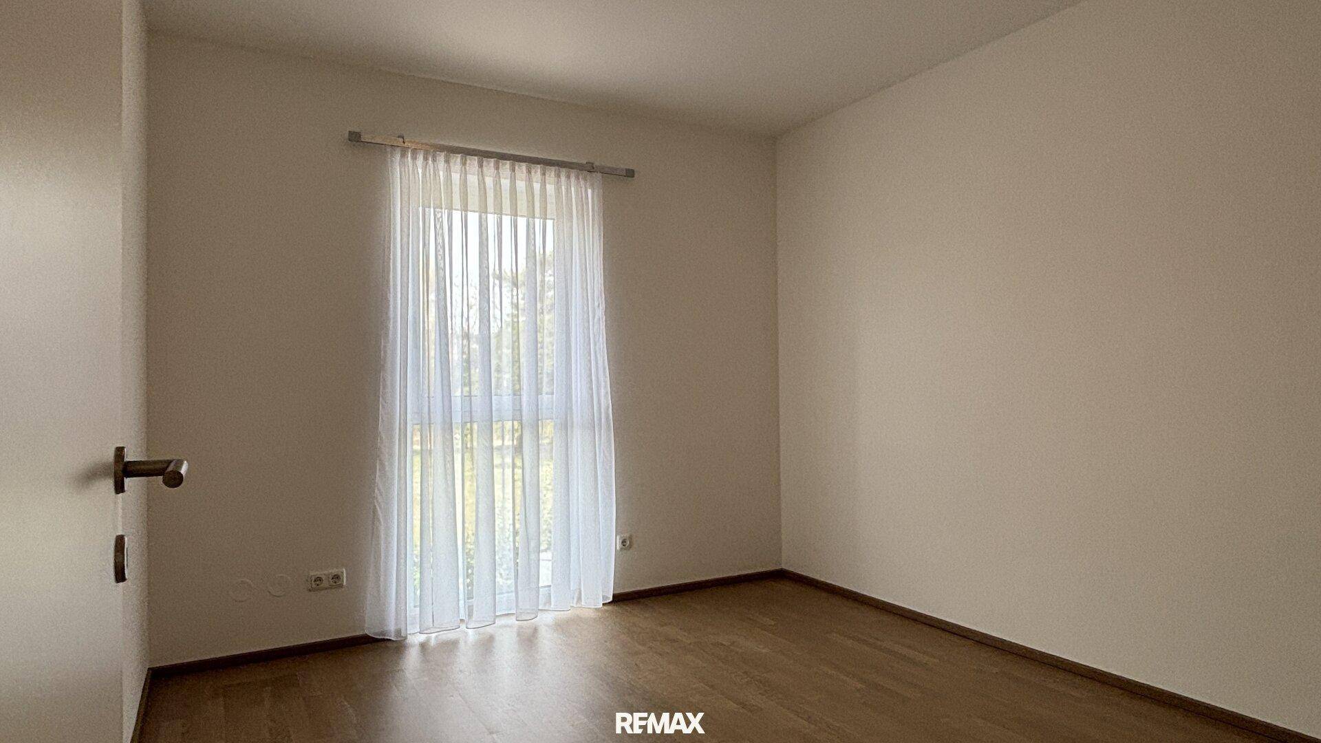 Freundliches Zimmer mit einem Fenster und elegantem Holzfußboden, bereit zur individuellen Gestaltung.