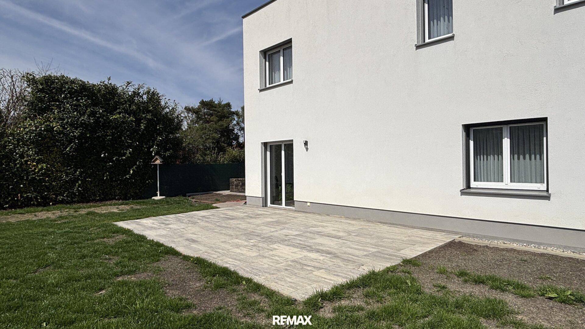 Große gepflasterte Terrasse mit direktem Zugang zum Garten, ideal für entspannte Stunden im Freien.