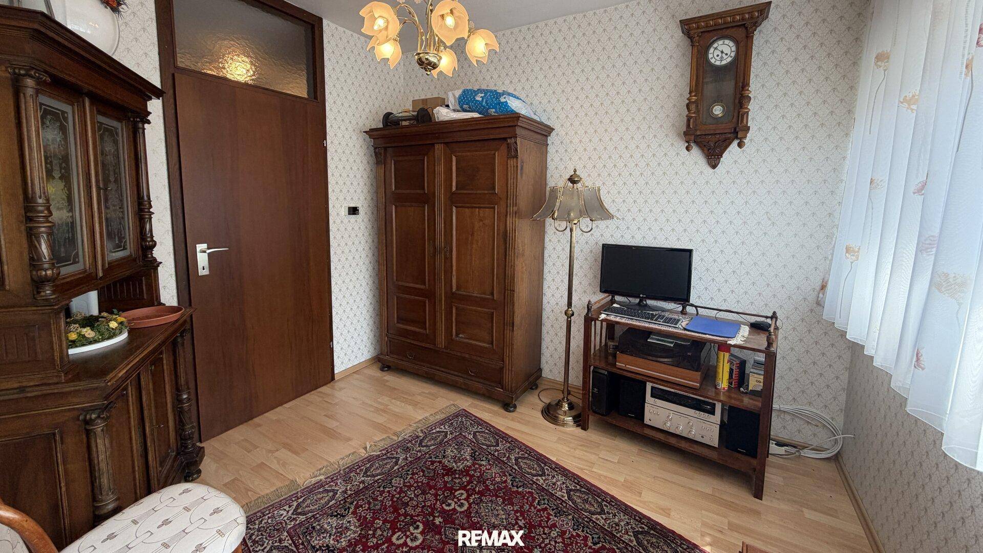 Arbeitszimmer mit Holzschrank, Schreibtisch und traditioneller Einrichtung.