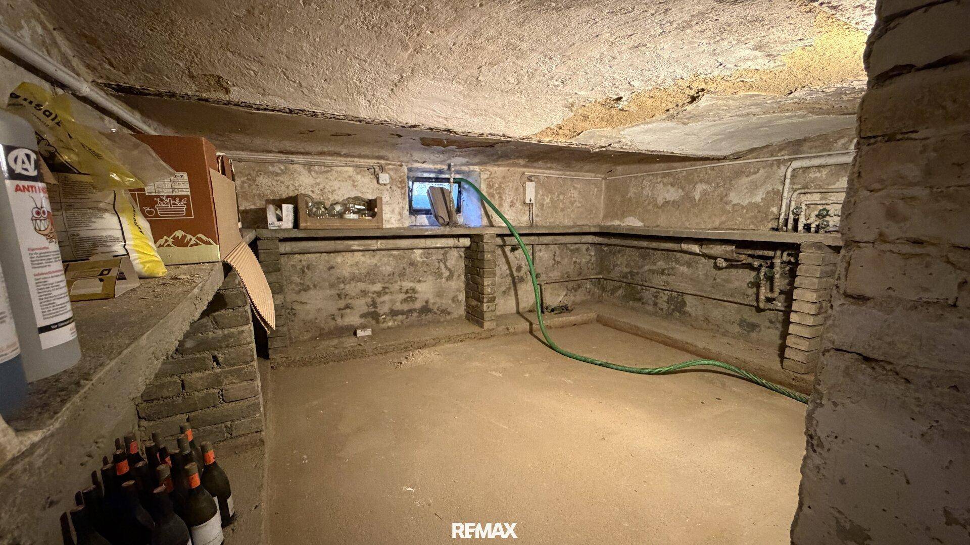 Unausgebauter Kellerraum mit unverputzten Wänden, Betonboden und sichtbaren Leitungen, ideal als Lager.