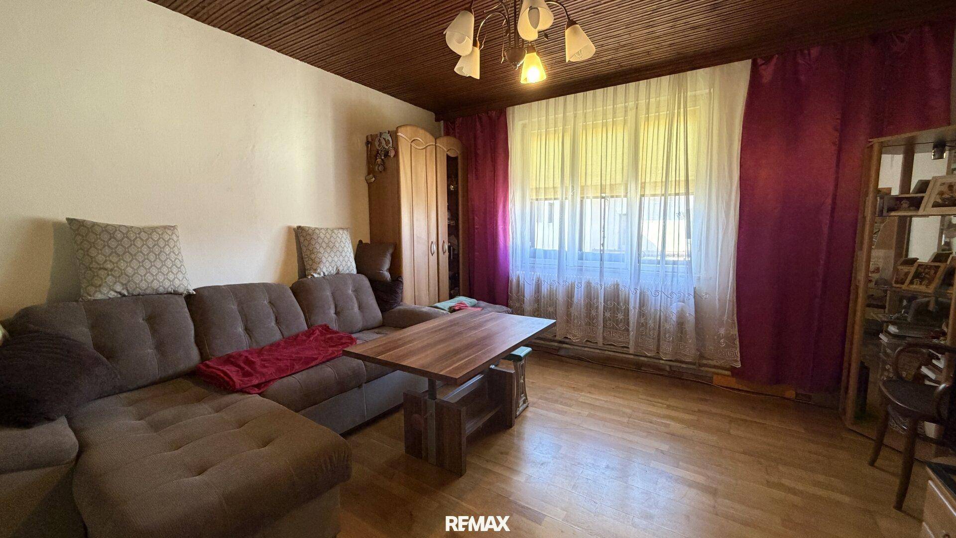 Geräumiges Wohnzimmer mit großem Sofa, Holzdecke und Couchtisch, ideal für entspannte Abende.