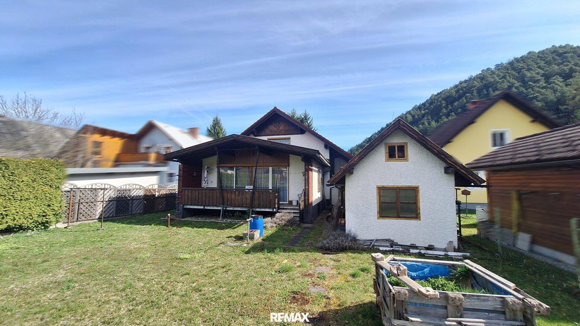 Rückseite des Hauses mit Garten, Terrasse und Blick auf die umliegende Landschaft.